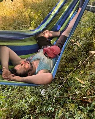 Photo d’un hamac vert et bleu, posé sur pied sous un chêne